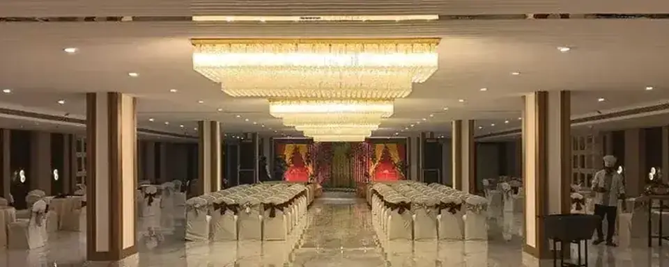 The same hall dressed for a wedding, with a floral stage and the buffet running along one side