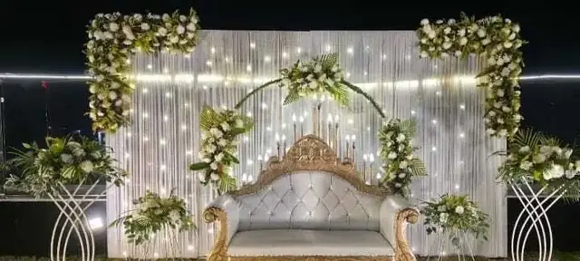 Wedding stage decorated with white floral drapes and fairy lights