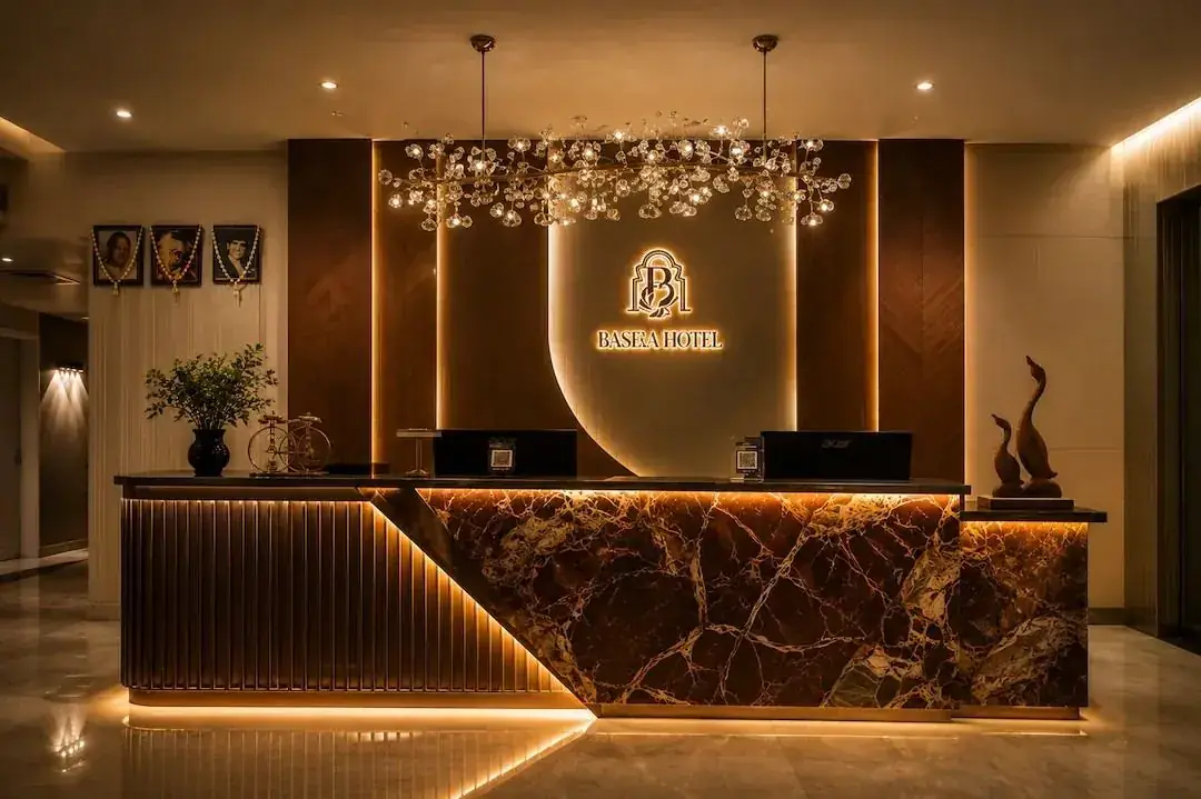 Reception desk at Basera Hotel beneath a crystal chandelier